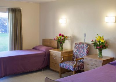 Oliva Vista double occupancy room with fresh flowers on the nightstand.